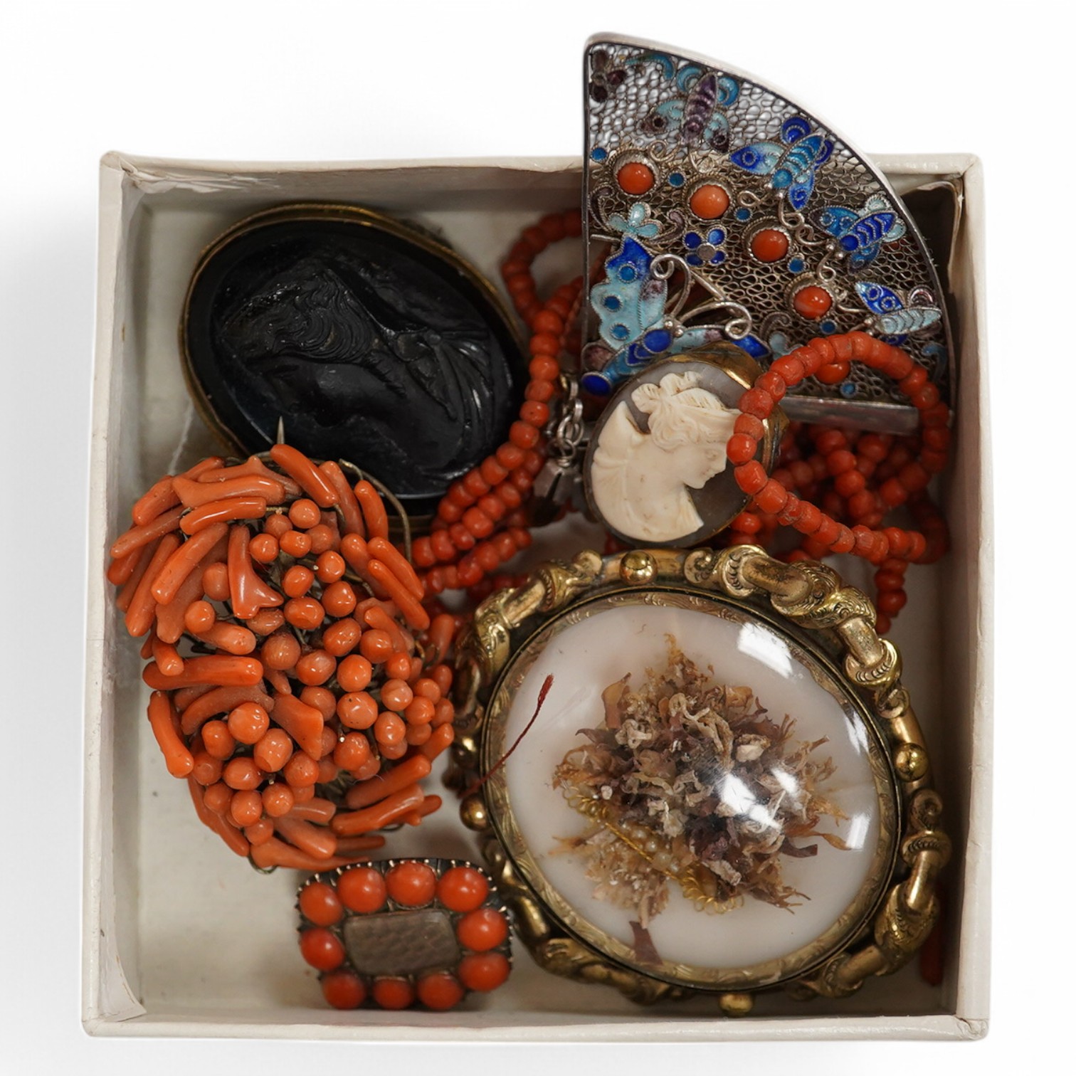 A Victorian yellow metal and coral bead set mourning brooch, with plaited hair beneath a glazed panel, 22mm, a filigree 925, coral and enamel set fan brooch and six other items including a coral branch and bead cluster b